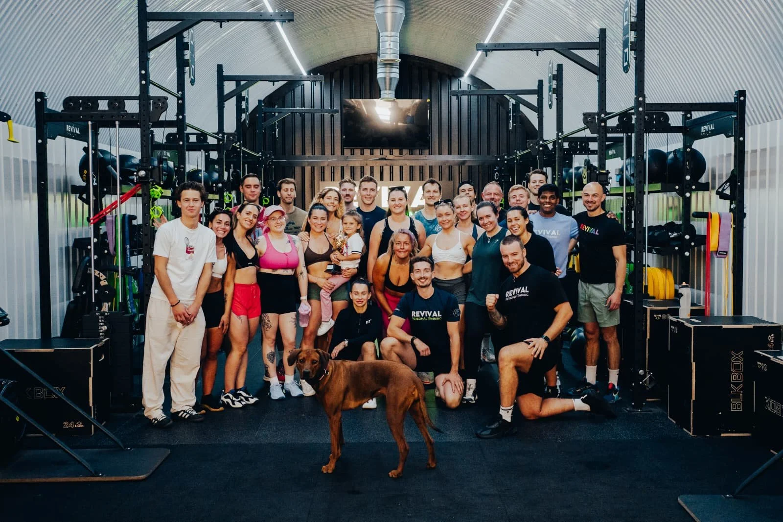 Group of smiling people posing for group photo in gym