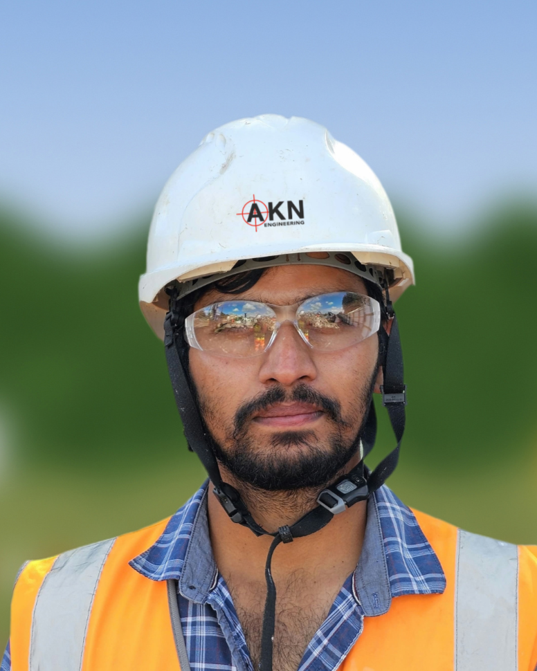 AKN Engineering, Site Engineer, wearing white hard hat with AKN Logo, safety glasses, and high vis jacket.