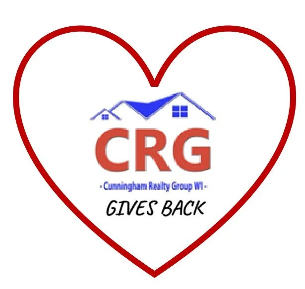A heart-shaped outline with a logo and text inside. The logo features a blue roof with a chimney and windows, and large red letters 'CRG' below it. Underneath, in smaller blue text, it says 'Cunningham Realty Group WI.' Below that, in black cursive, it says 'GIVES BACK.'