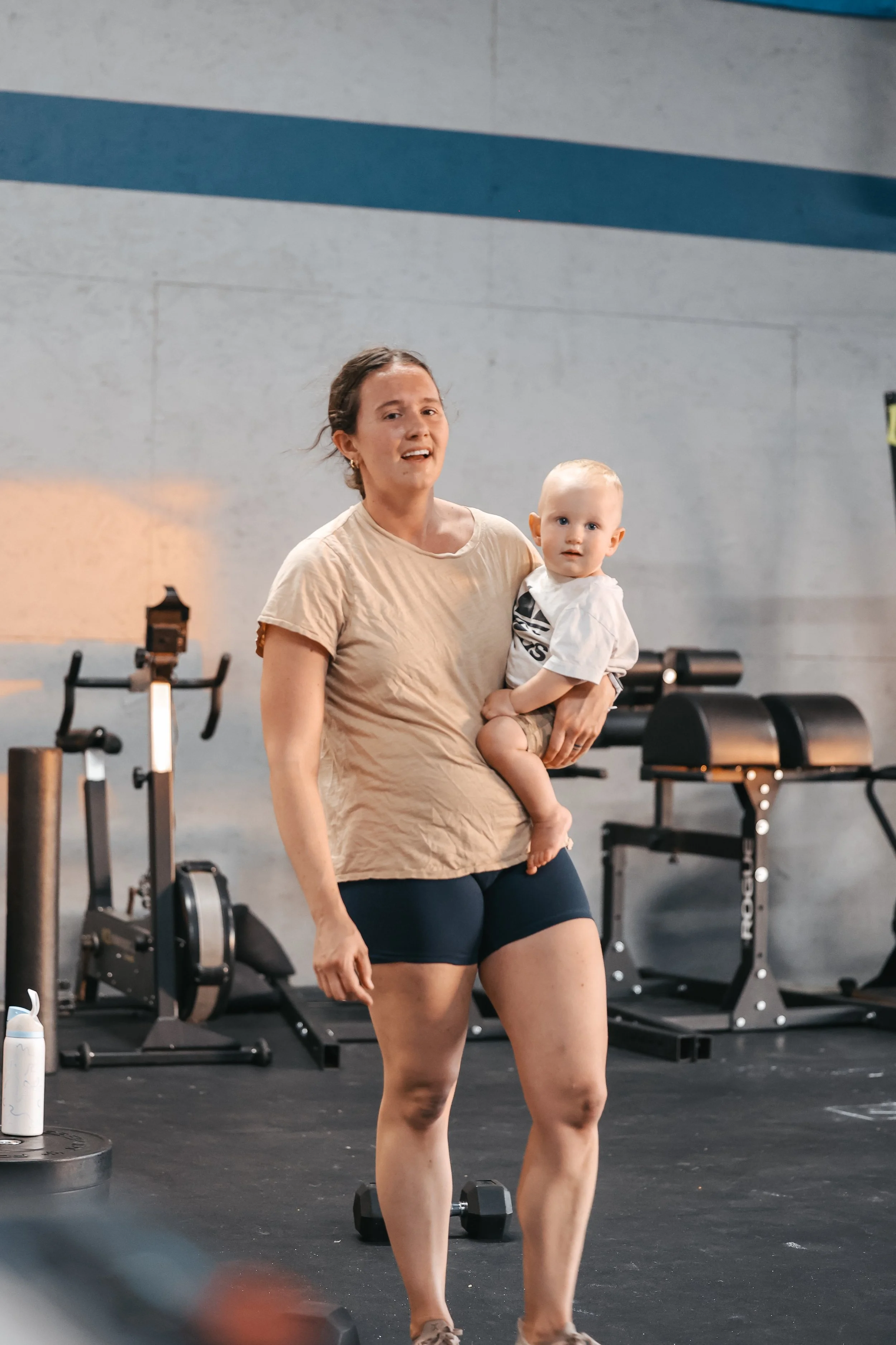 Mom holding her baby at Einhorn Training Co., a gym with childcare in New Braunfels, TX