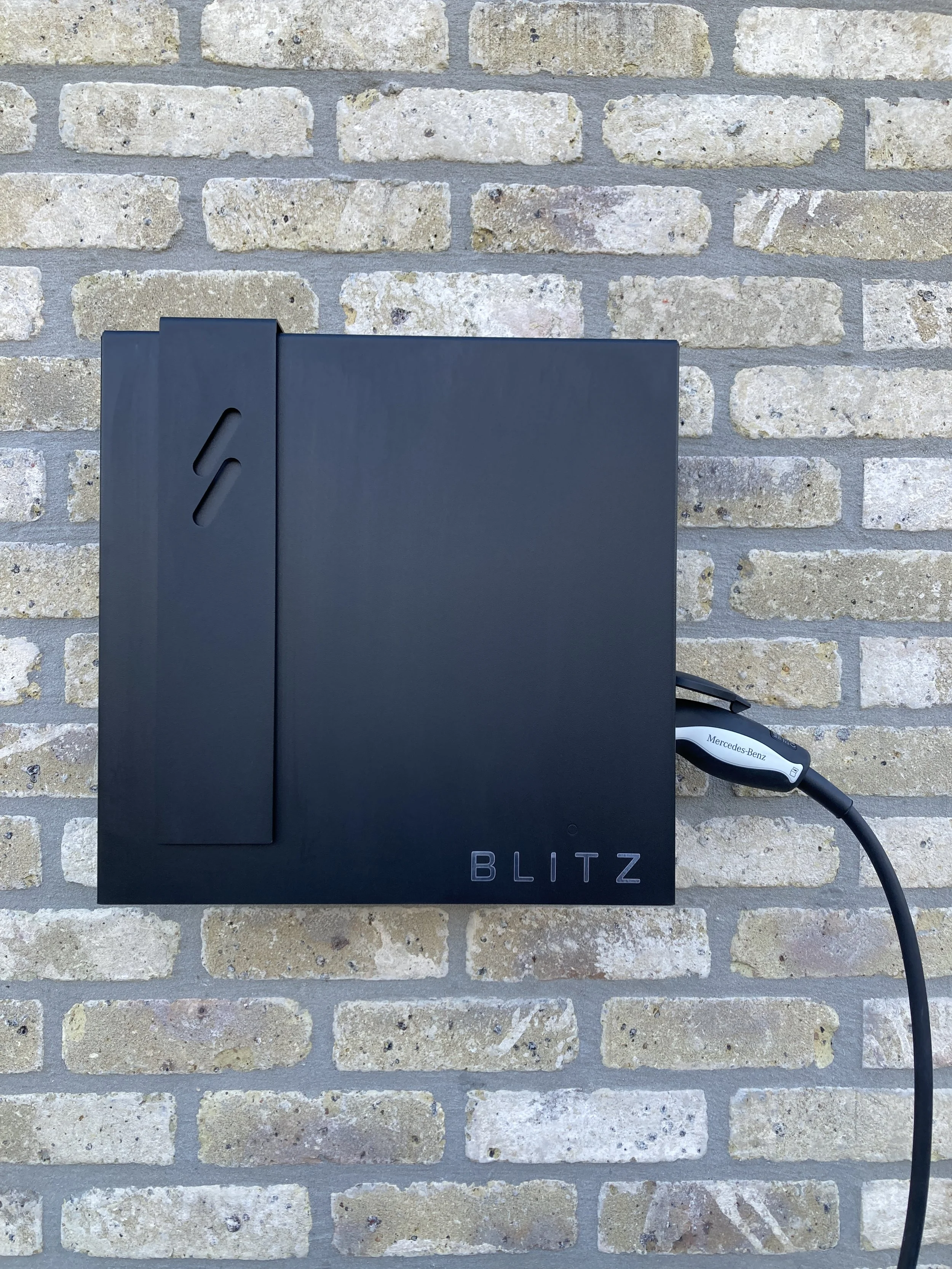 Blitz laadstation aan een bakstenen muur