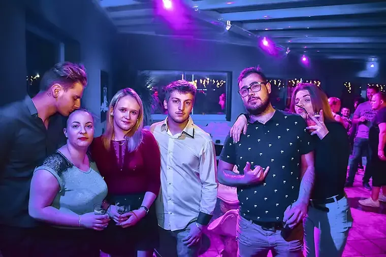 Group poses at a neon birthday gathering