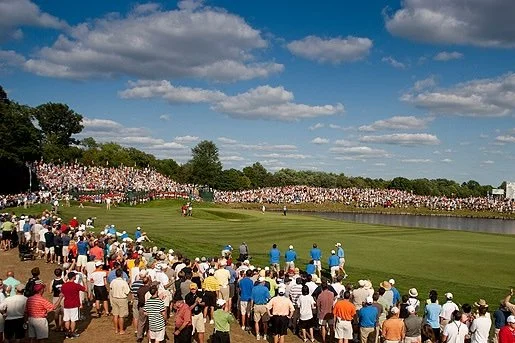Crowd of spectators watching a golf tournament on a sunny day