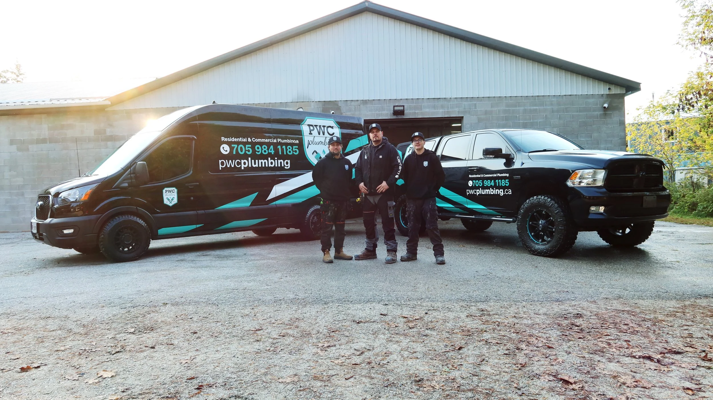 PWC Plumbing team standing in front of their service trucks in Springwater, Ontario.