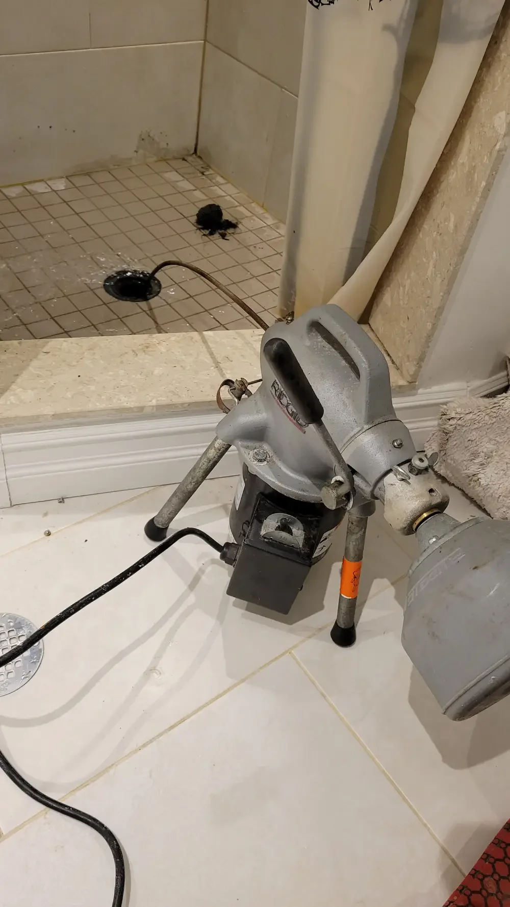 Drain snaking machine clearing a clogged shower drain during residential drain cleaning service in Springwater, Ontario.
