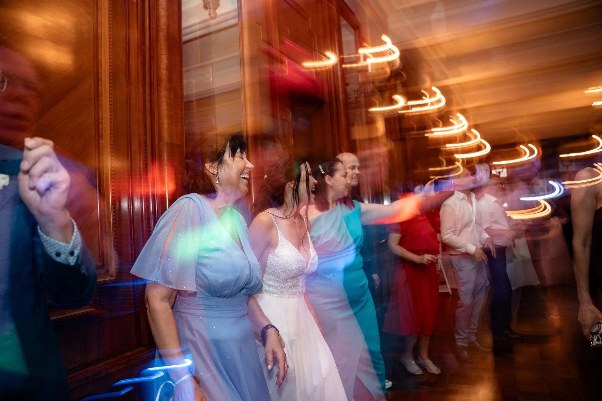 Menschen tanzen und lachen bei einer Feier in einem festlich dekorierten Raum mit warmem Licht