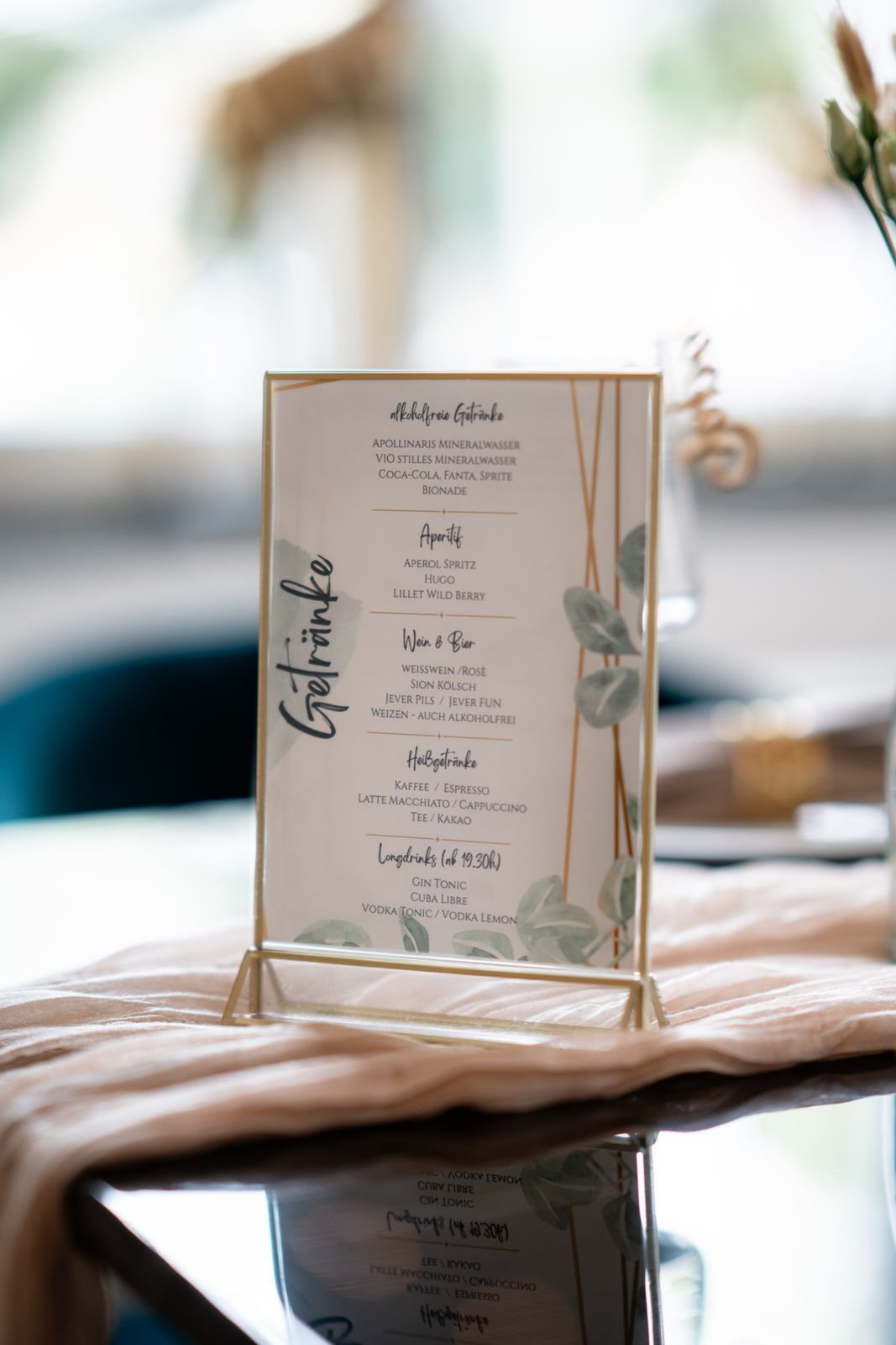 Speisekarte für alkoholfreie Getränke, Aperitifs, Wein und Bier, Heißgetränke und Longdrinks, mit grünen Blätterdekor auf der rechten Seite, auf einem Tisch mit rosa Stoff