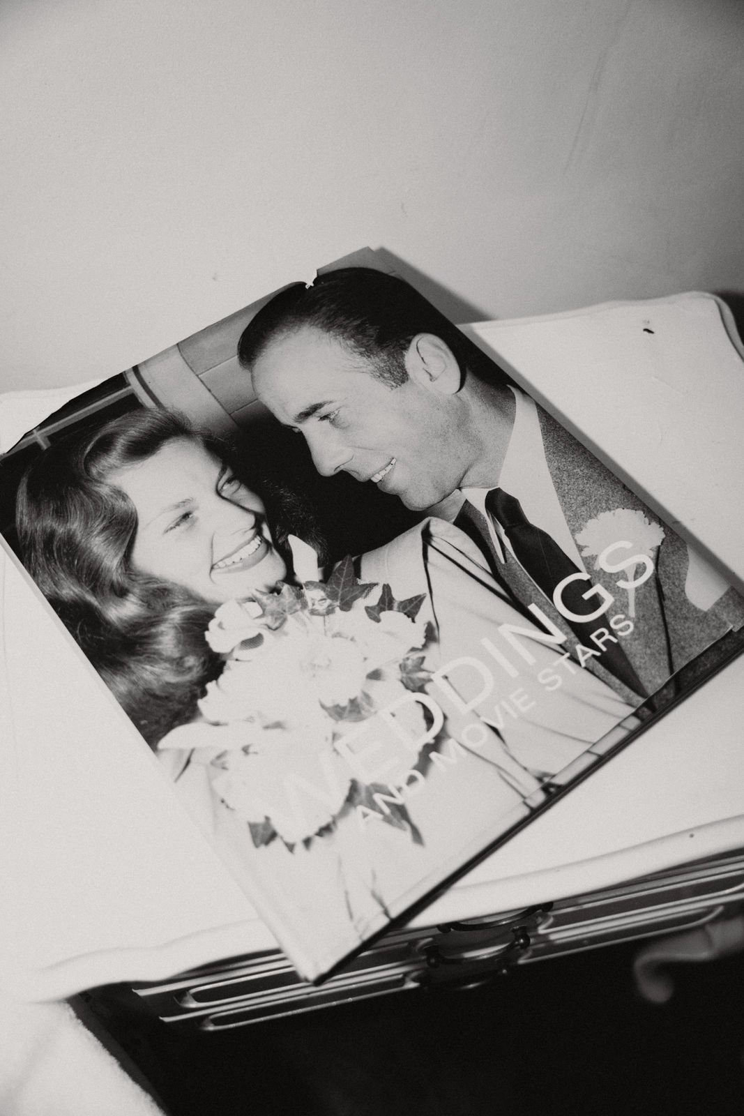 Schwarz-weiß-Foto eines Magazins mit einem Bild eines glücklichen Paares, das sich anschaut, mit Blumen in der Hand, auf einem weißen Tisch liegend.