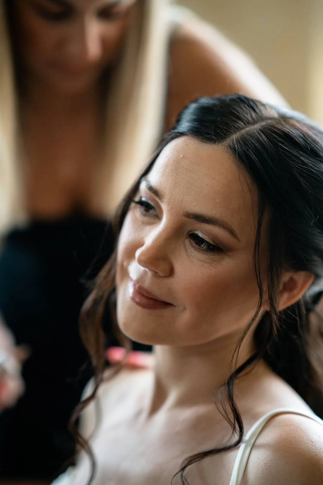 Frau mit dunklen Haaren wird von einer another Frau mit blondem Haar frisiert, Nahaufnahme