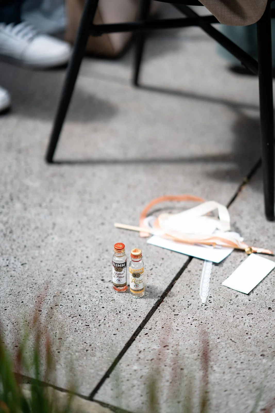 Zwei Fläschchen mit Alkohol, ein Stück Papier und eine Maskerade auf einem Boden.