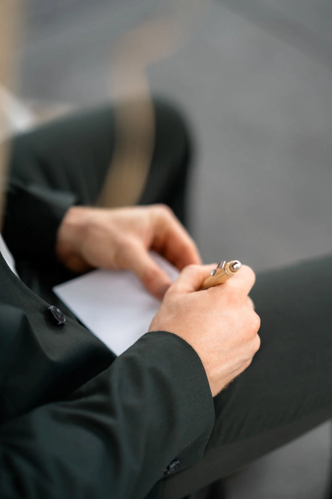 Person schreibt mit einem Stift auf einem Notizblock.