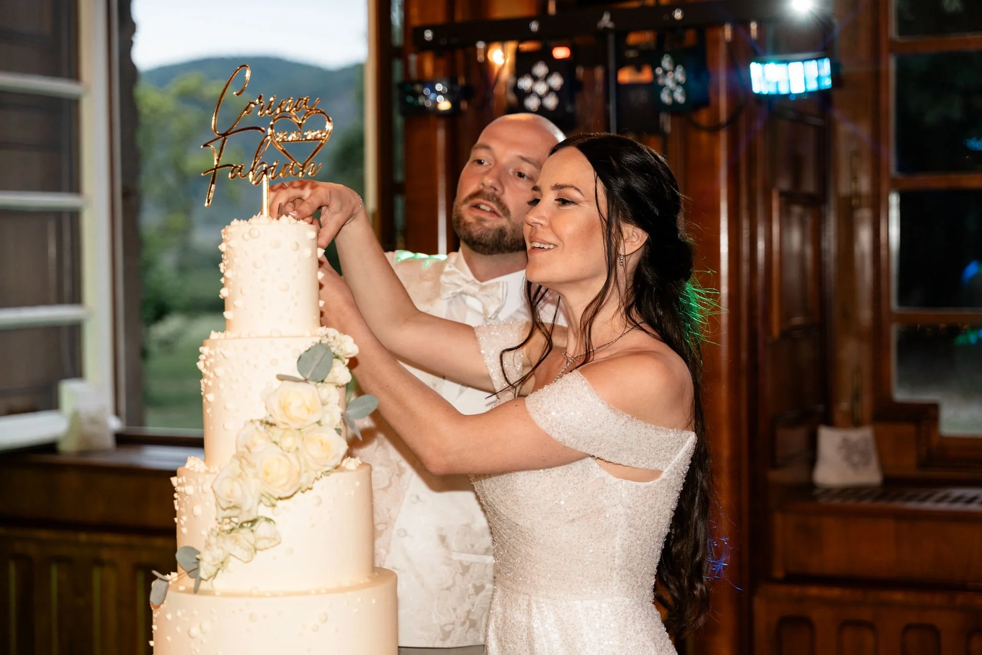 Ein Paar schneidet eine Hochzeitstorte bei ihrer Feier