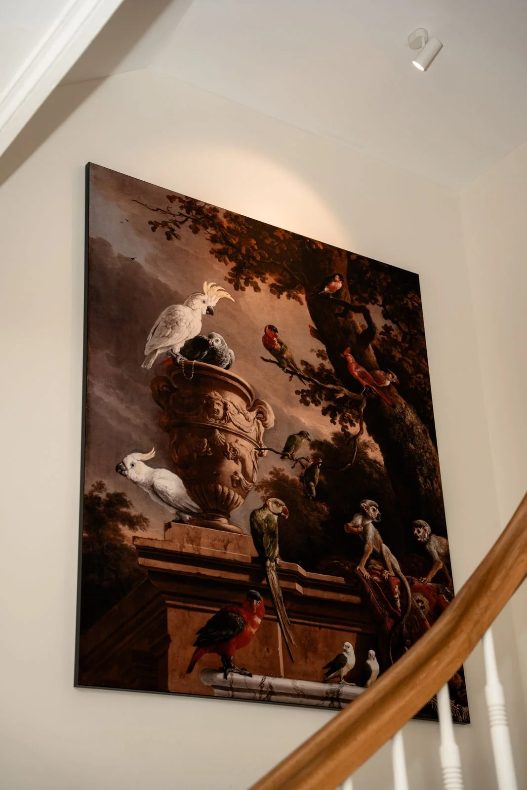 Gemälde mit verschiedenen Vögeln auf einem Baum und einer antiken Vase, in einem Innenraum aufgehängt.