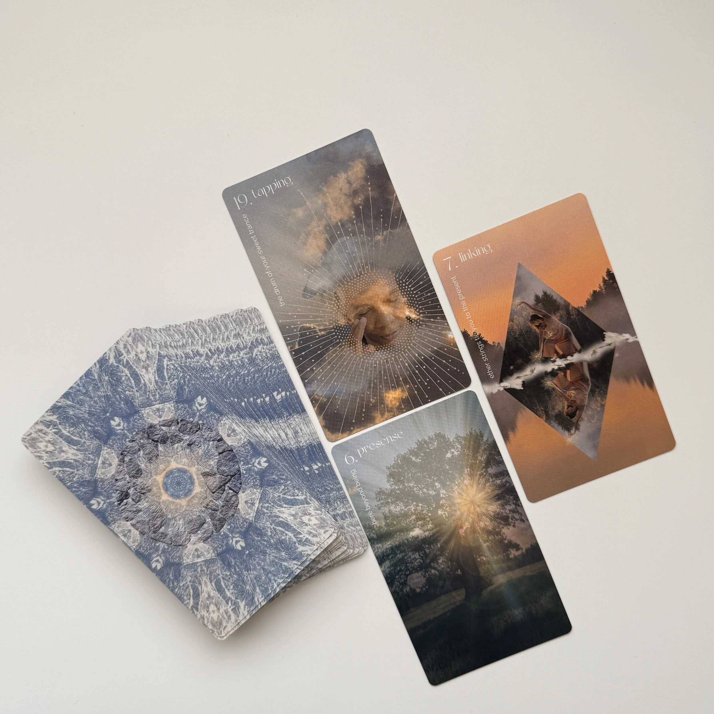 A set of tarot or oracle cards spread out on a white surface, featuring nature-themed and mystical imagery.