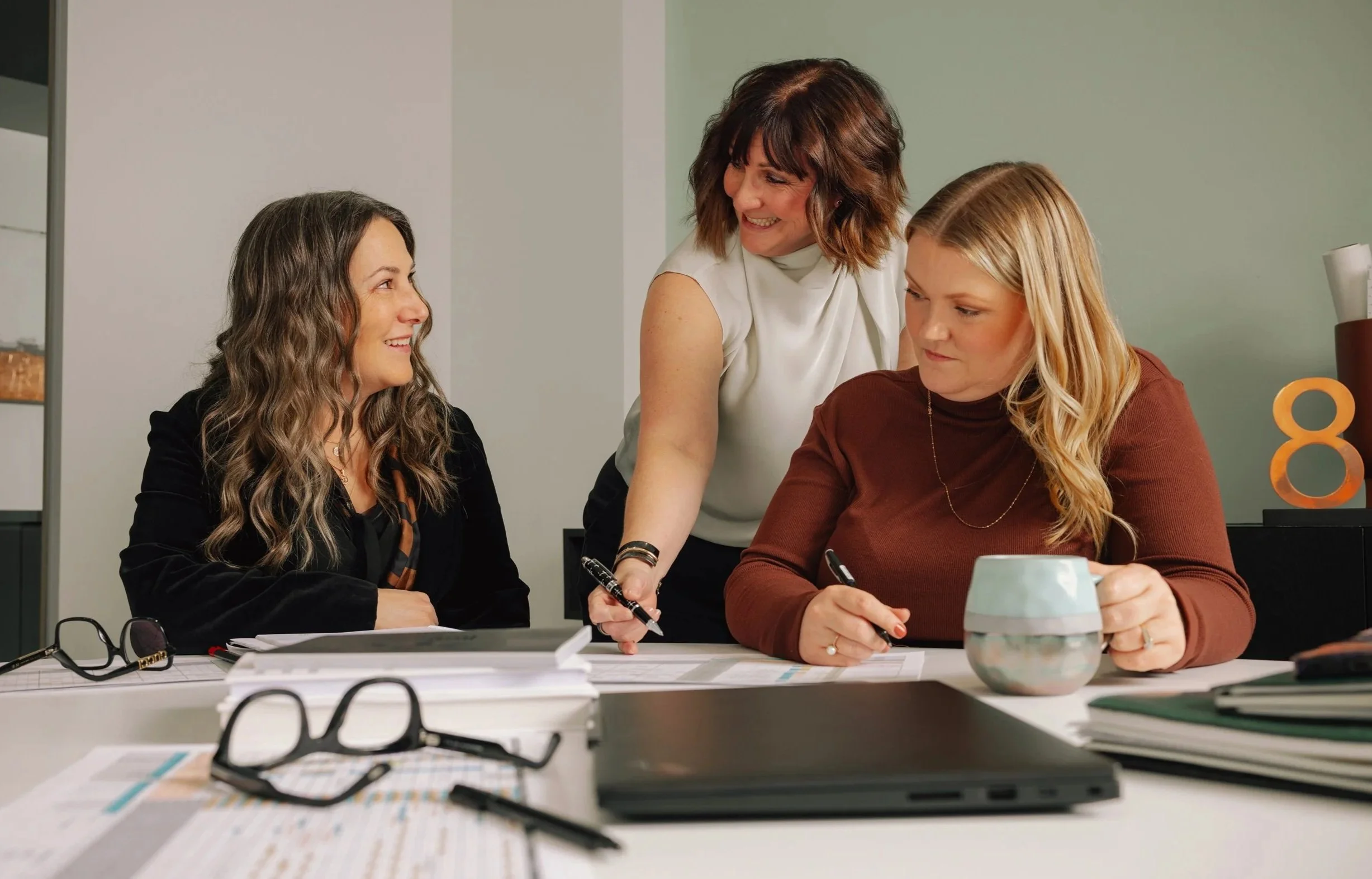 The Copper 8 team happily working at a desk together.