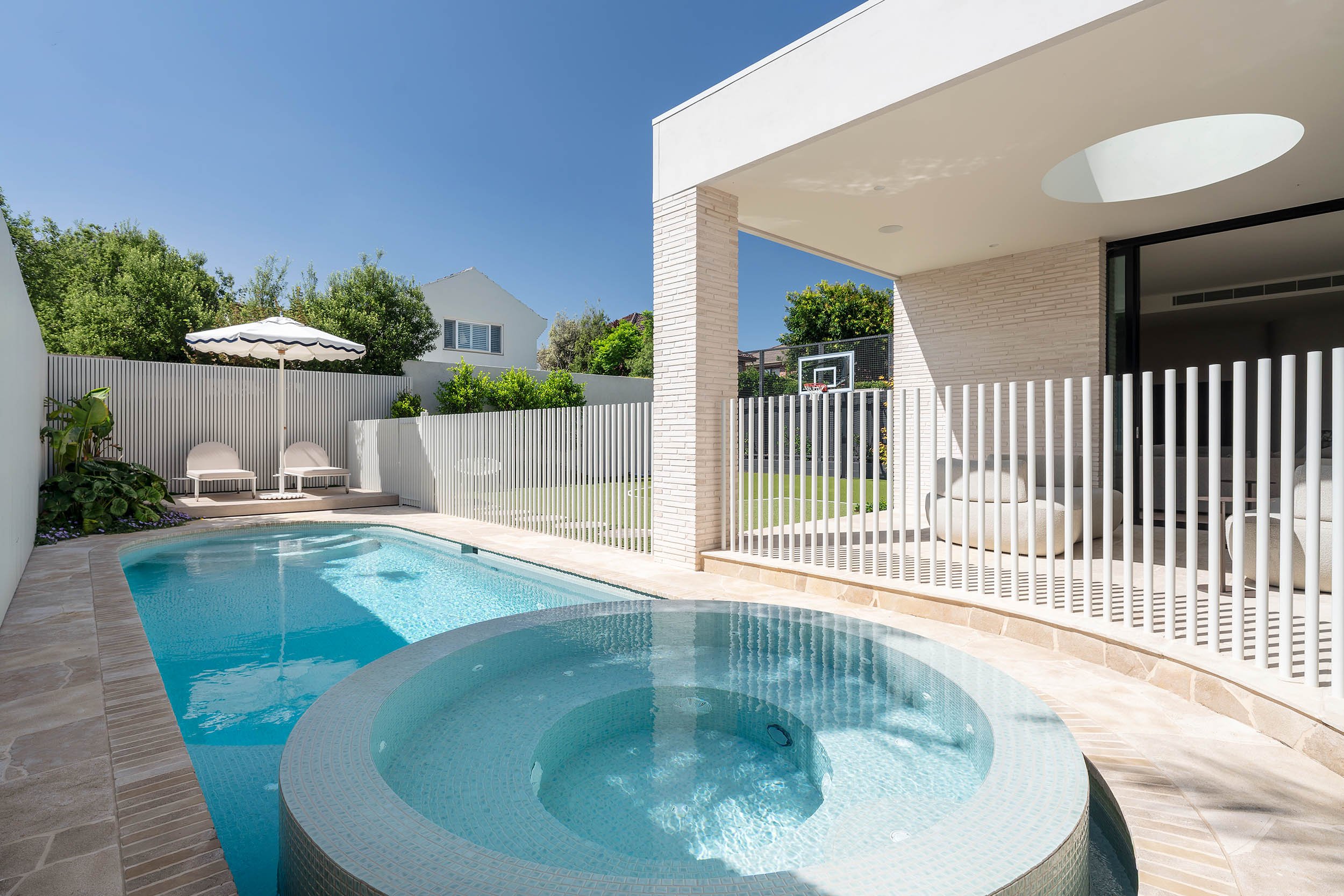 Modern Curved Pool and Spa Located in Brighton by Mint Design