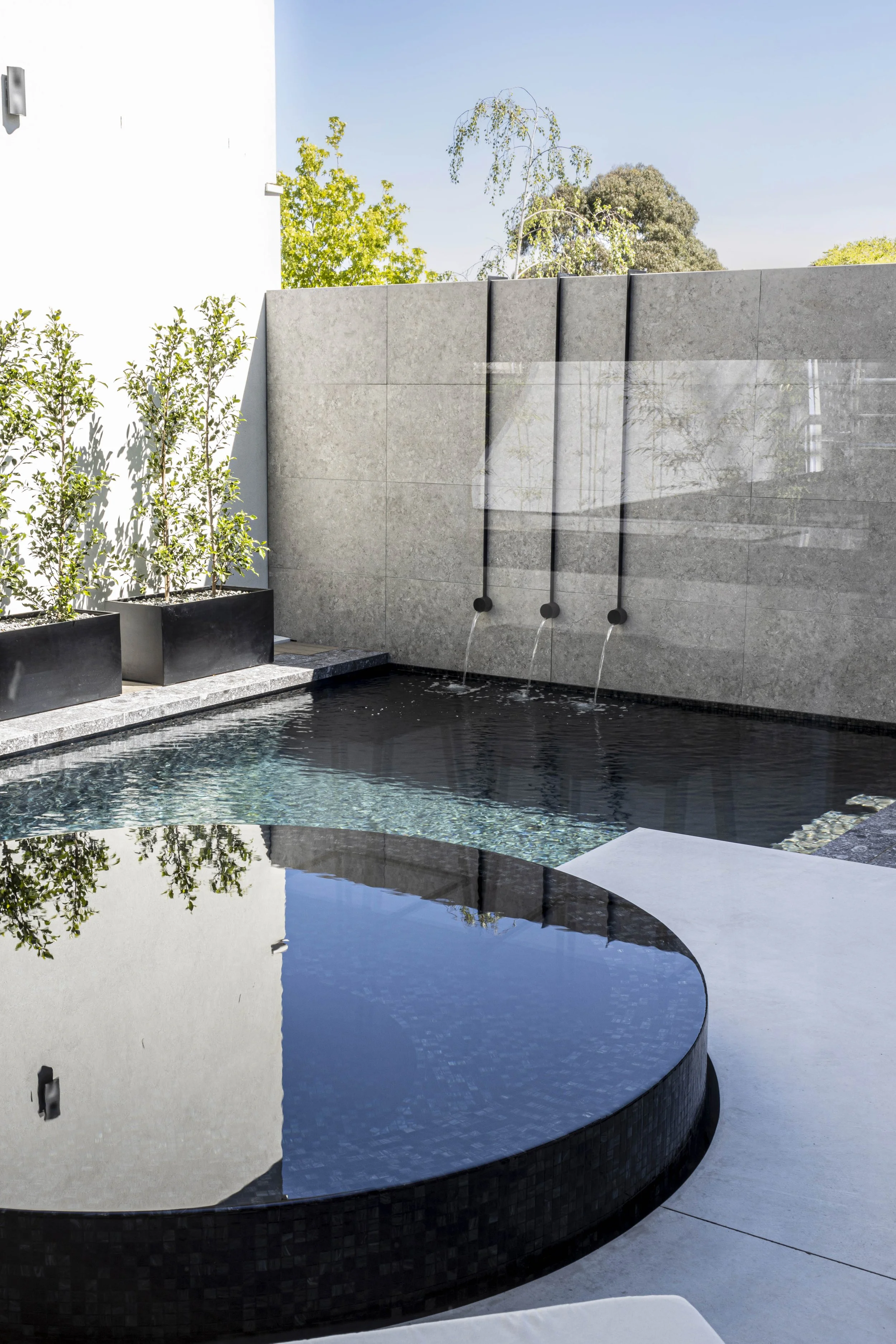 Pool with three water spouts into pool by Mint Landscape Design in Torquay