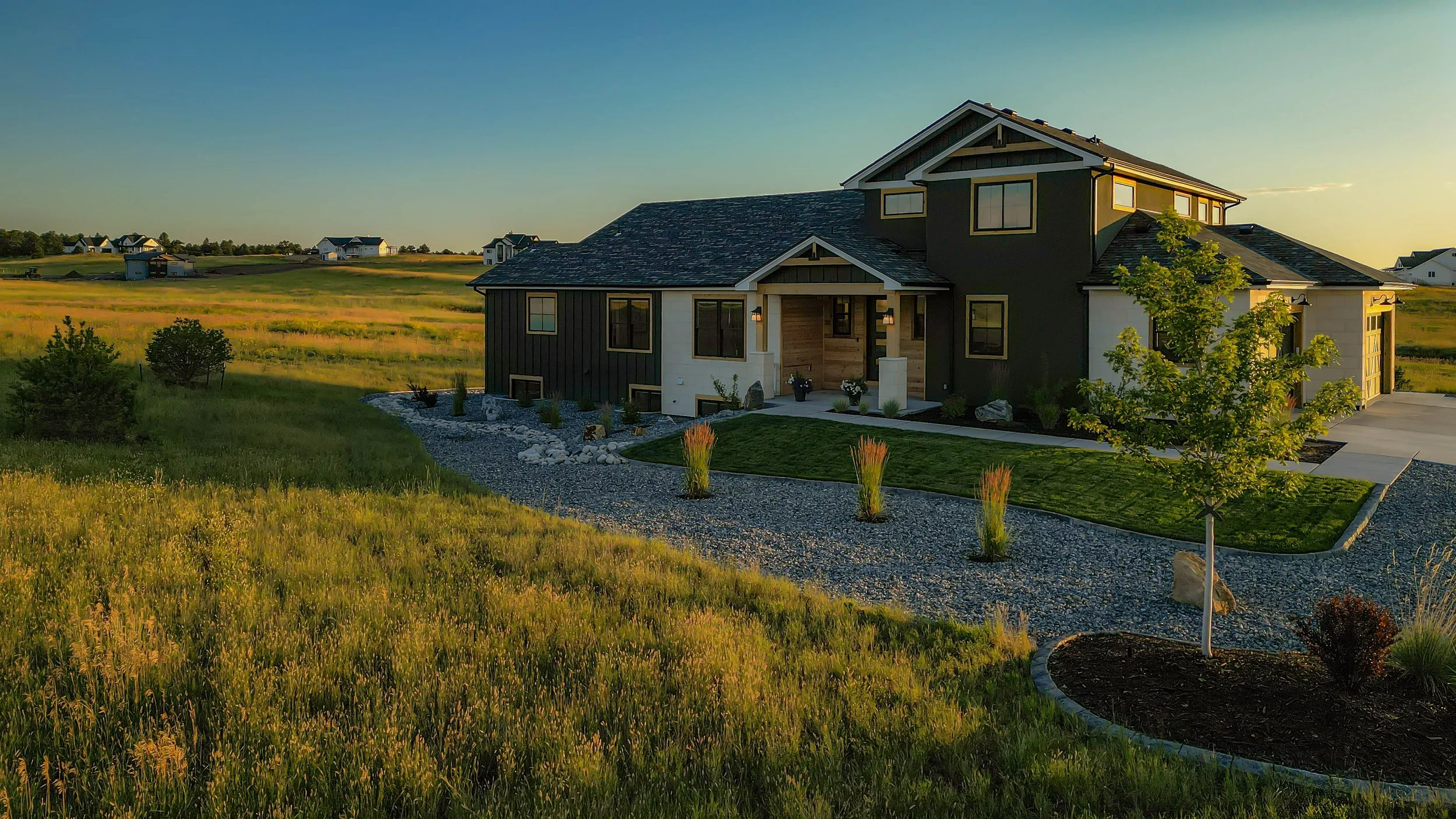 A picture of a home taken at sunset surrounded by gorgeous landscaping by Fisk Lawnscapes
