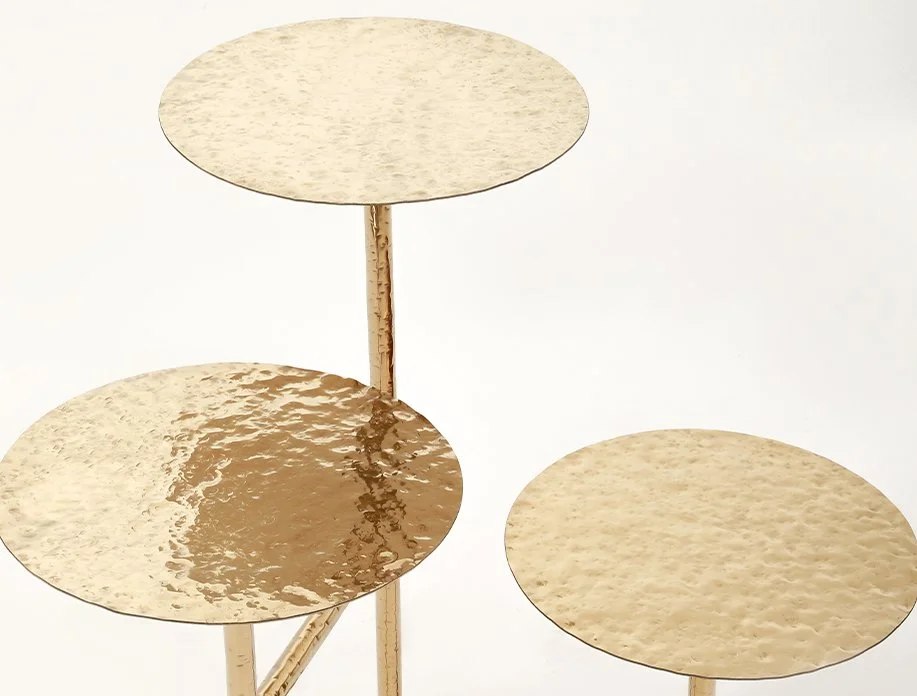 The three textured brass tabletops of the sculptural Liquid Table Gold by Furn Object