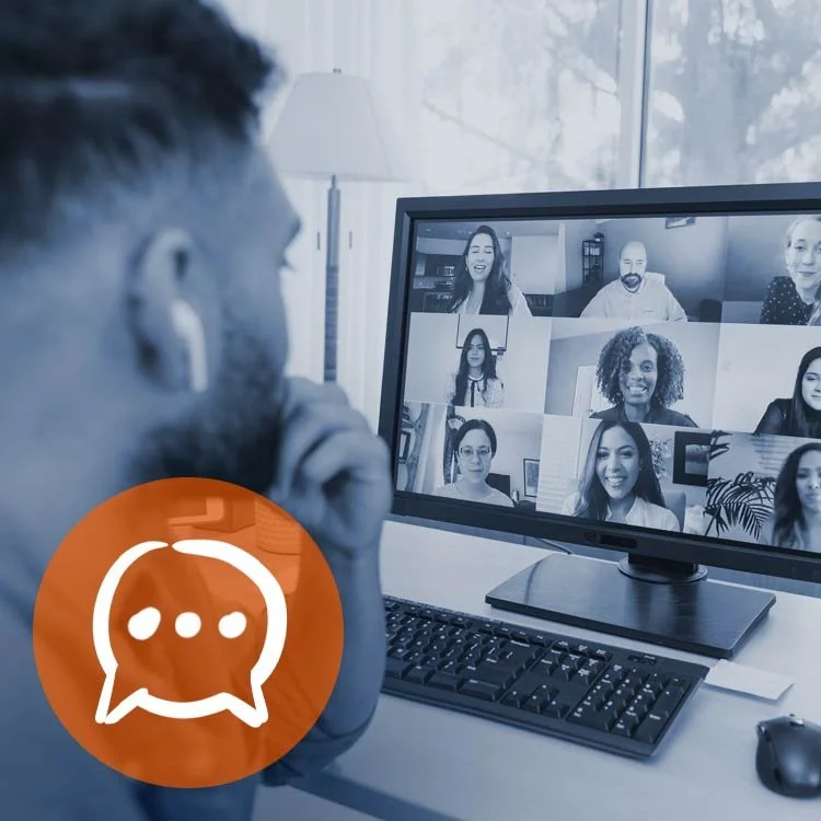 A person has a video call on a computer with multiple diverse participants visible on the screen.