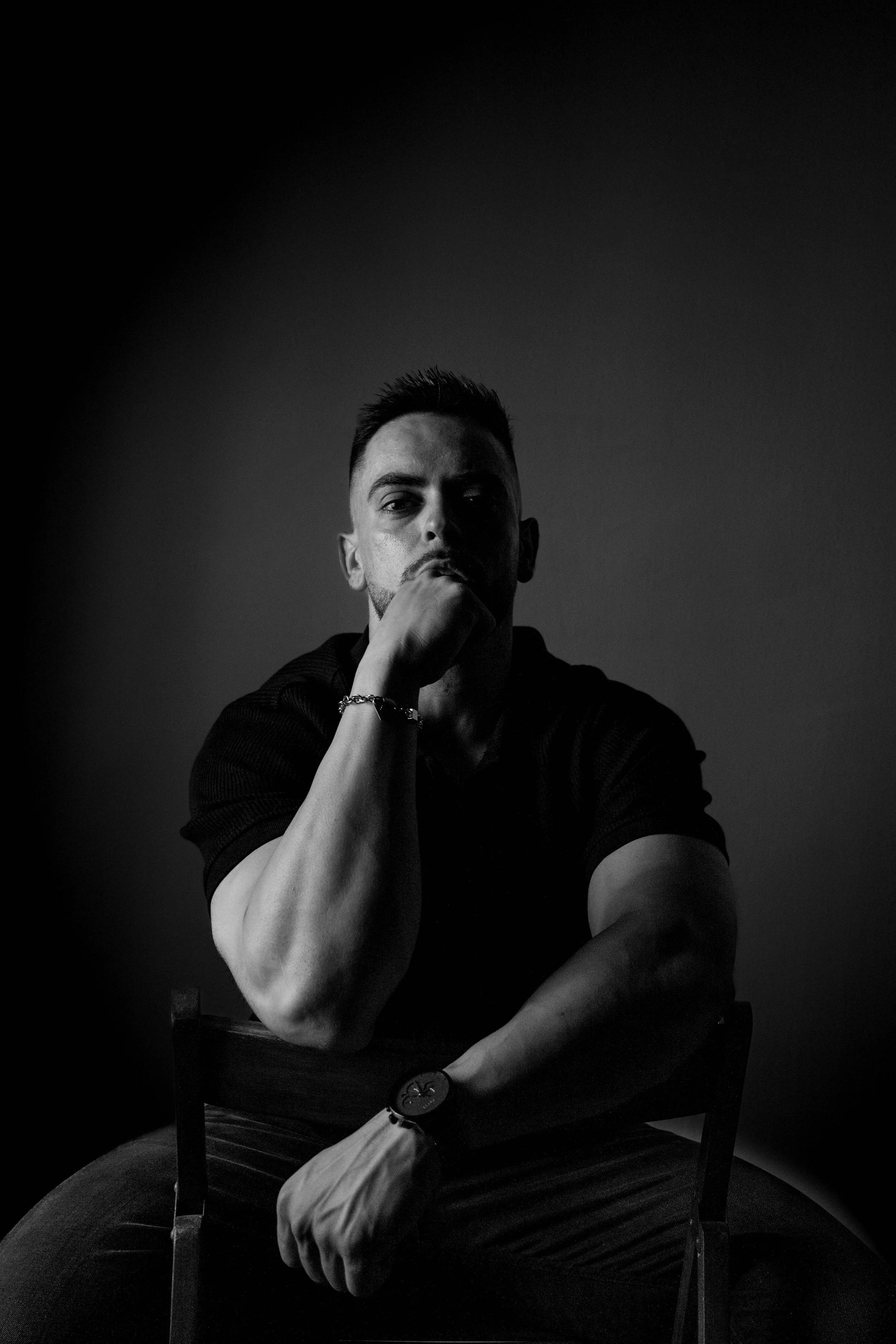 Imagen en blanco y negro con enfoque minimalista, destacando la expresión y la presencia del sujeto mediante una iluminación controlada. La fotografía low-key aporta dramatismo y un carácter introspectivo que favorece su uso en campañas visuales y ga