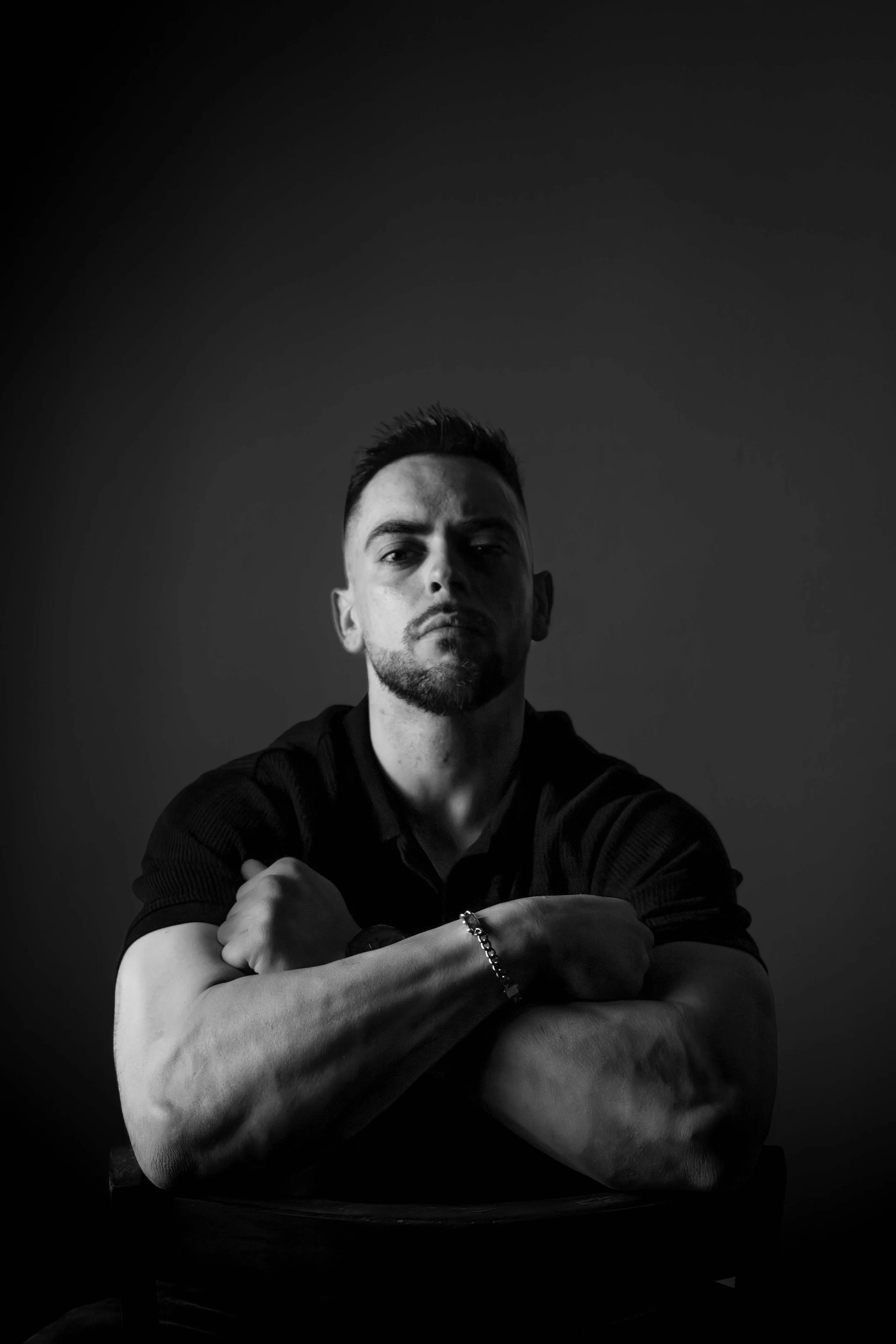 Retrato artístico en clave baja que utiliza sombras pronunciadas para crear una imagen de fuerza y serenidad. La iluminación suave desde un lateral define los rasgos con precisión, aportando profundidad visual. Un trabajo de fotografía profesional de