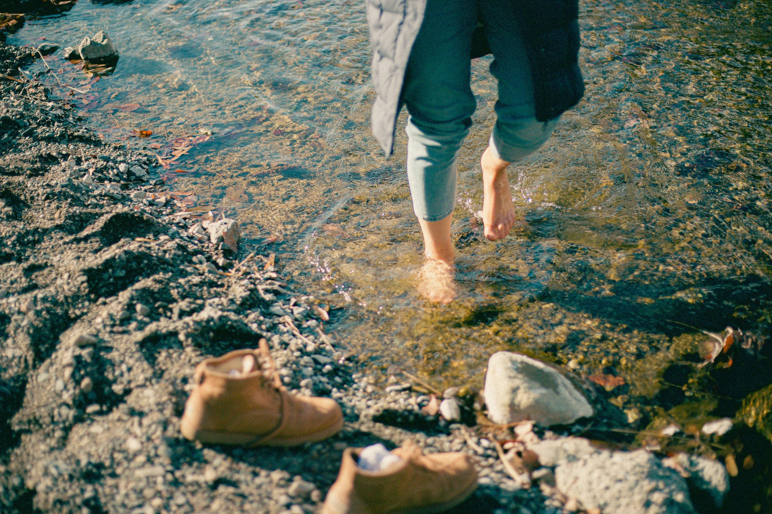 Bare feet on water representing grounding and healing after trauma therapy.