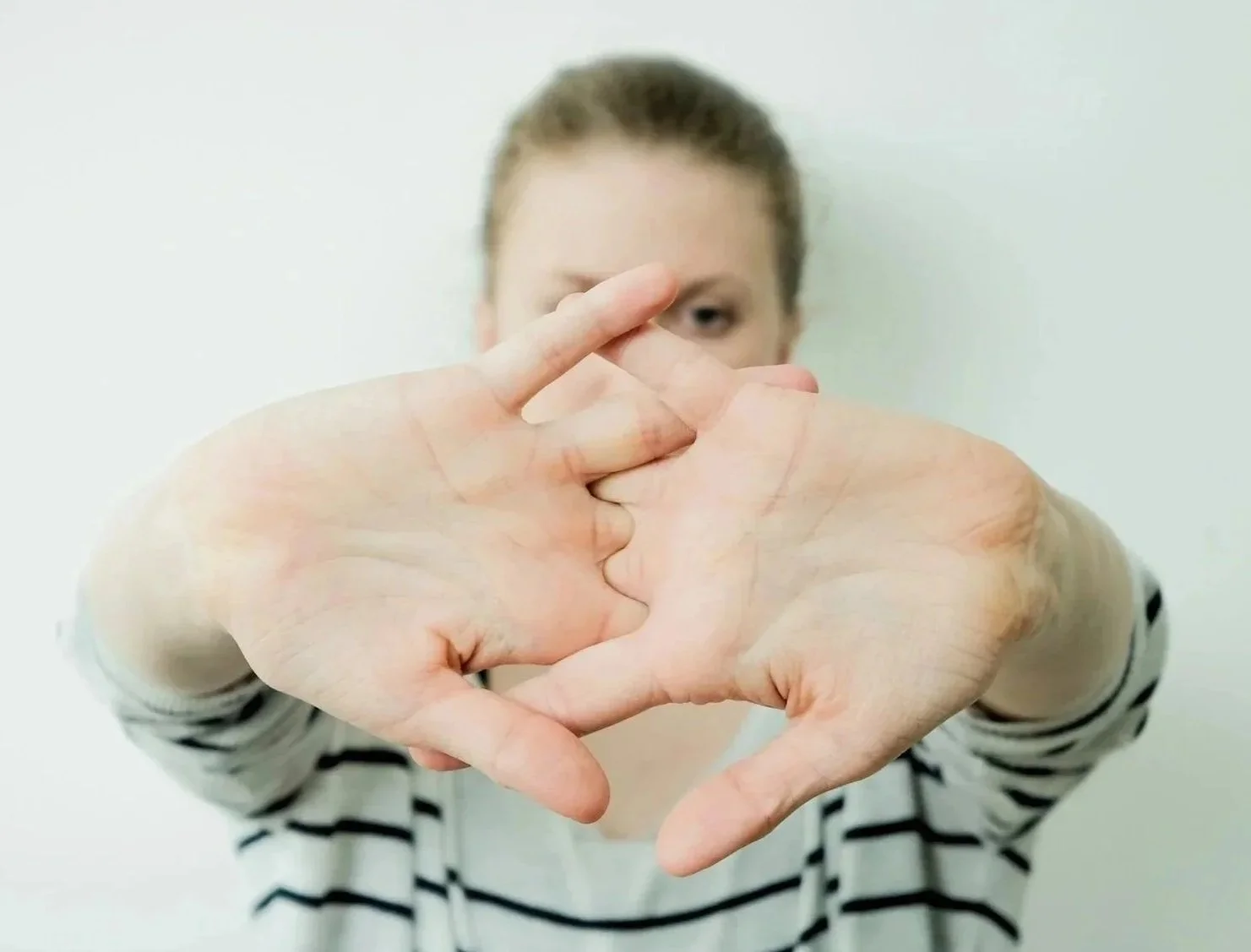 Hands with fingers crossed representing hope and healing from chronic flight trauma response