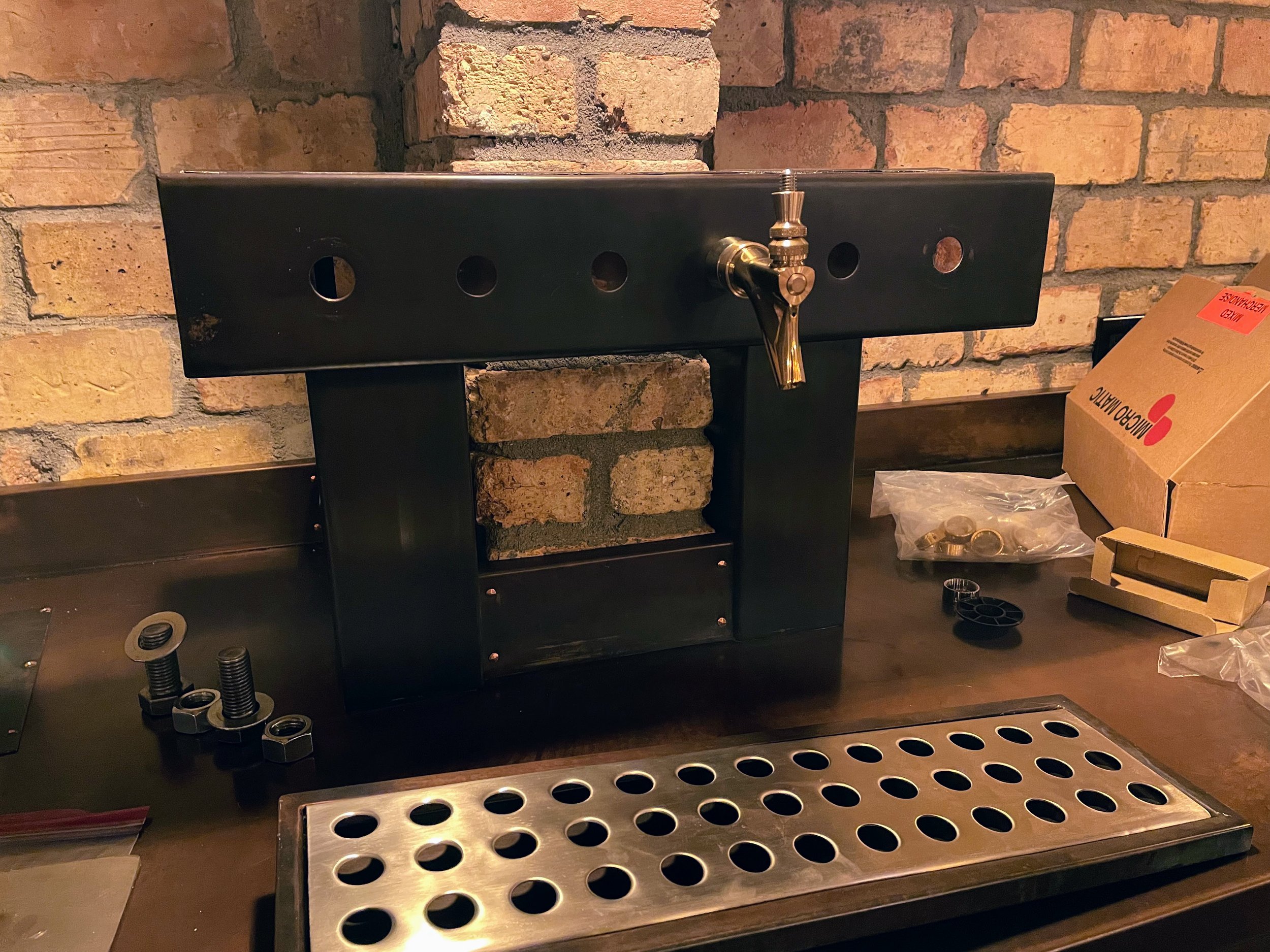 Custom copper draft beer tower being outfitted with polished Micro Matic 304 PVD brass faucets, professionally installed by Tapworks Northwest at a Northwest Washington bar