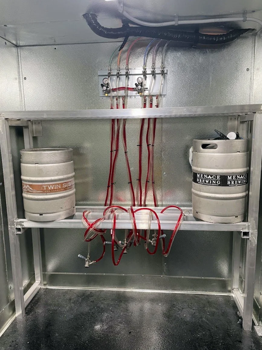 Professional draft system setup in walk-in cooler featuring Micro Matic secondary CO2 regulator panel and stainless steel keg couplers, installed by Tapworks Northwest for a Northwest Washington bar