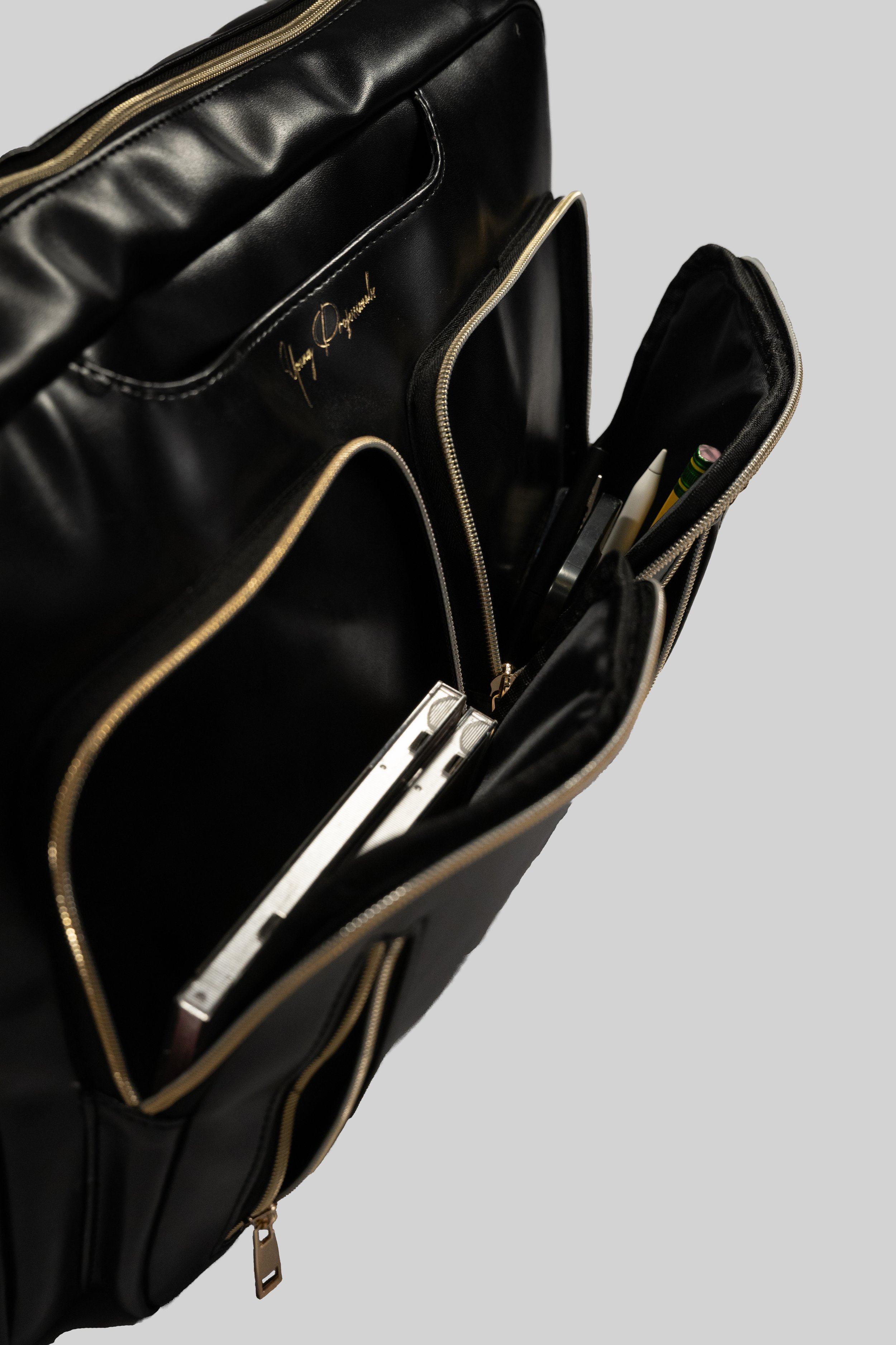 Accessory product photography in San Francisco. Backpack / briefcase with contents from Young Professionals on white background.