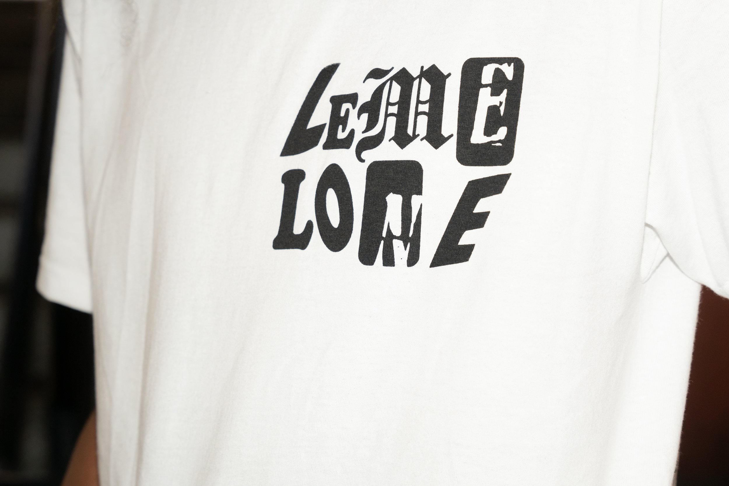 White T-shirt with black text saying "Lemme LONE" in a stylized font.
