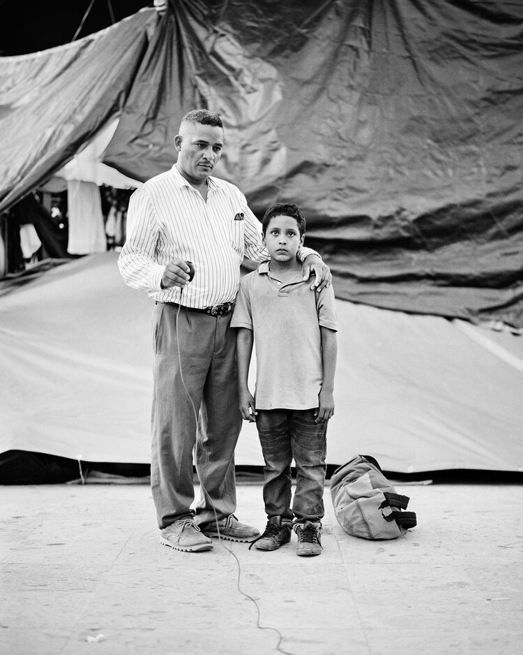 12. Eduardo Benavides, 40, with his son Jonathan, 9, from El Salvador, at an informal migrant camp in Reynosa, Mexico. Photograph by Eduardo Benavides and Adam Ferguson.