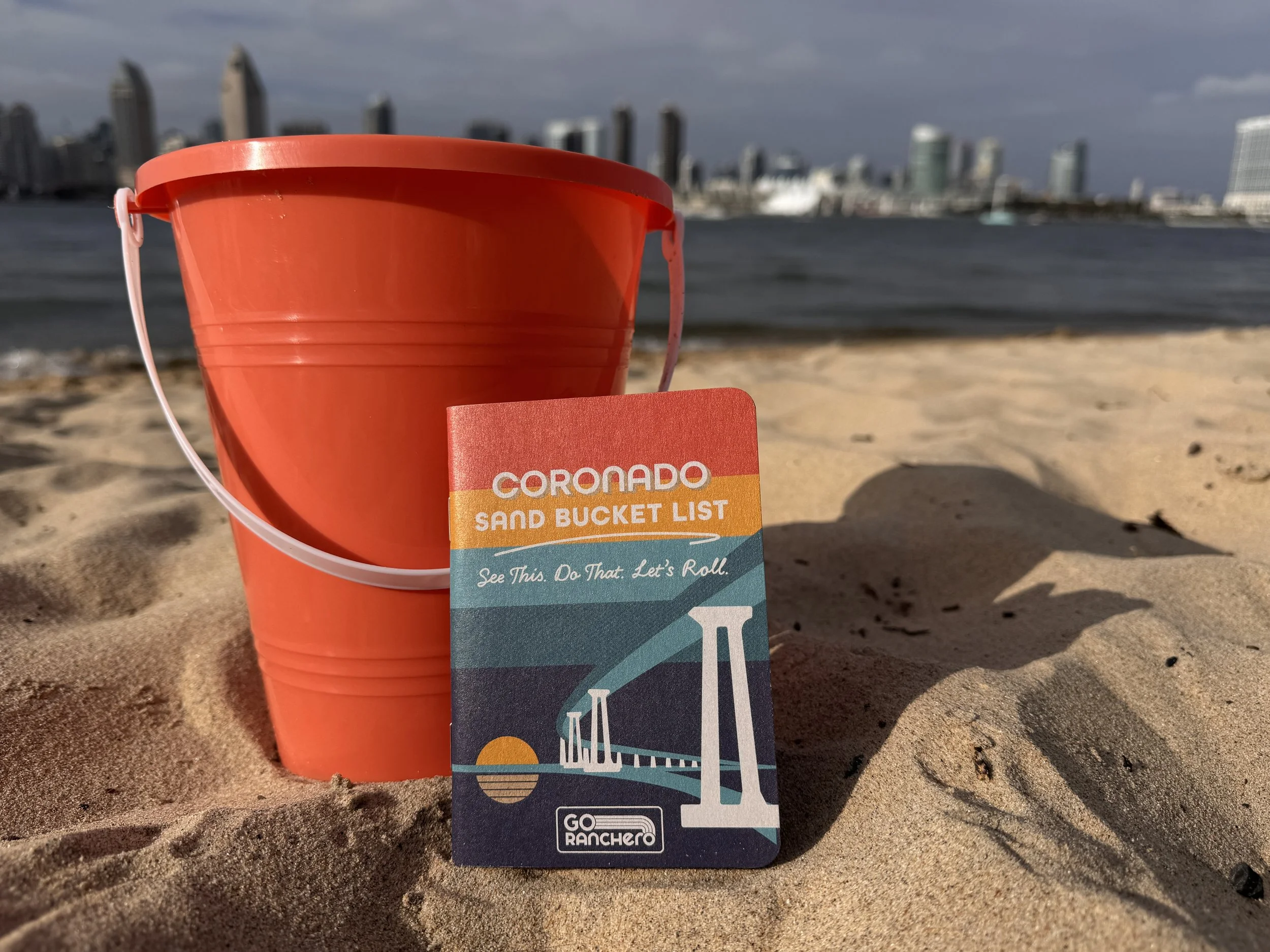 Coronado Sand Bucket List by Go Ranchero with a red sand bucket on the beach in Coronado, California