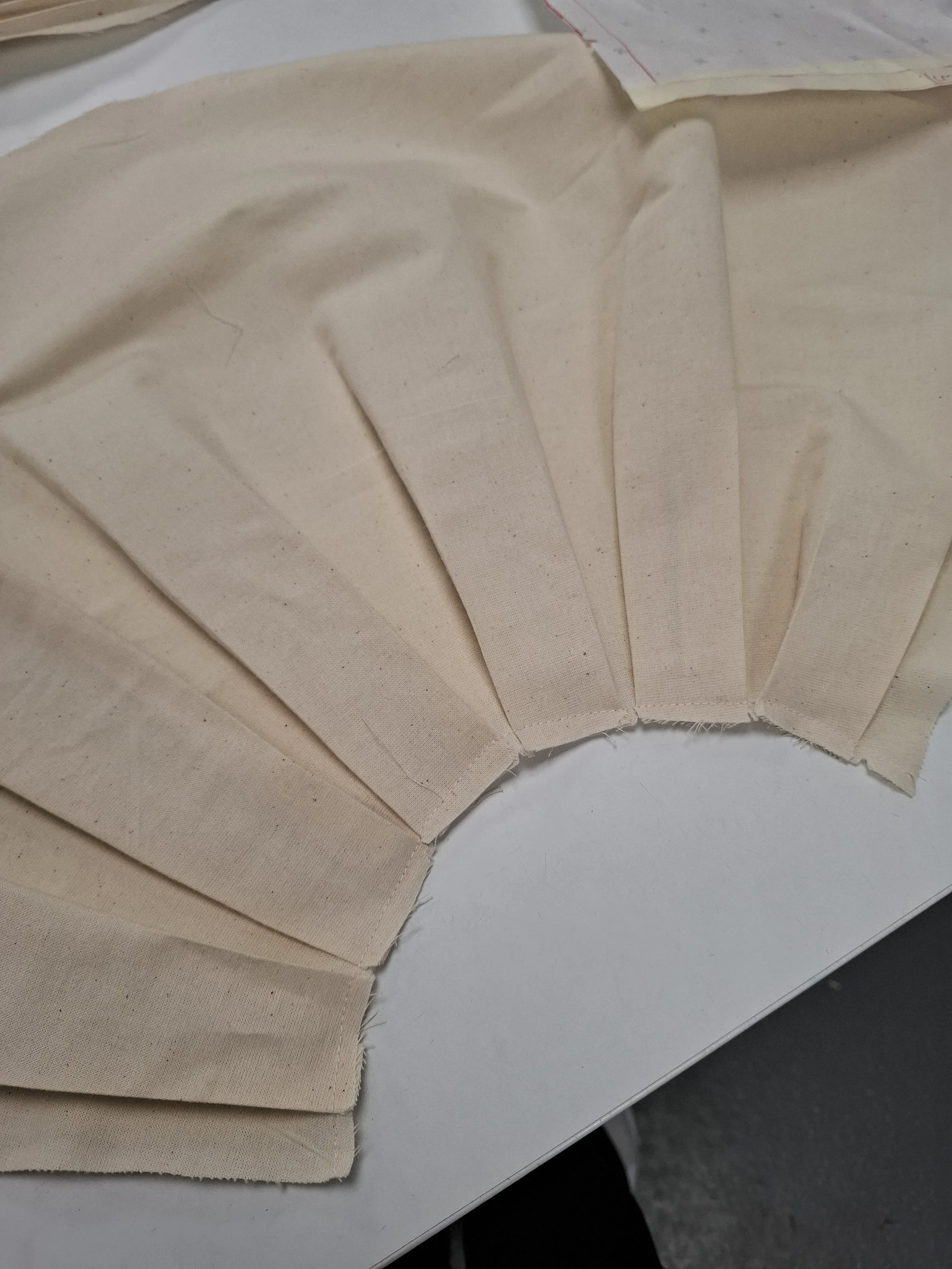 Toiling a box pleated sleeve hem.