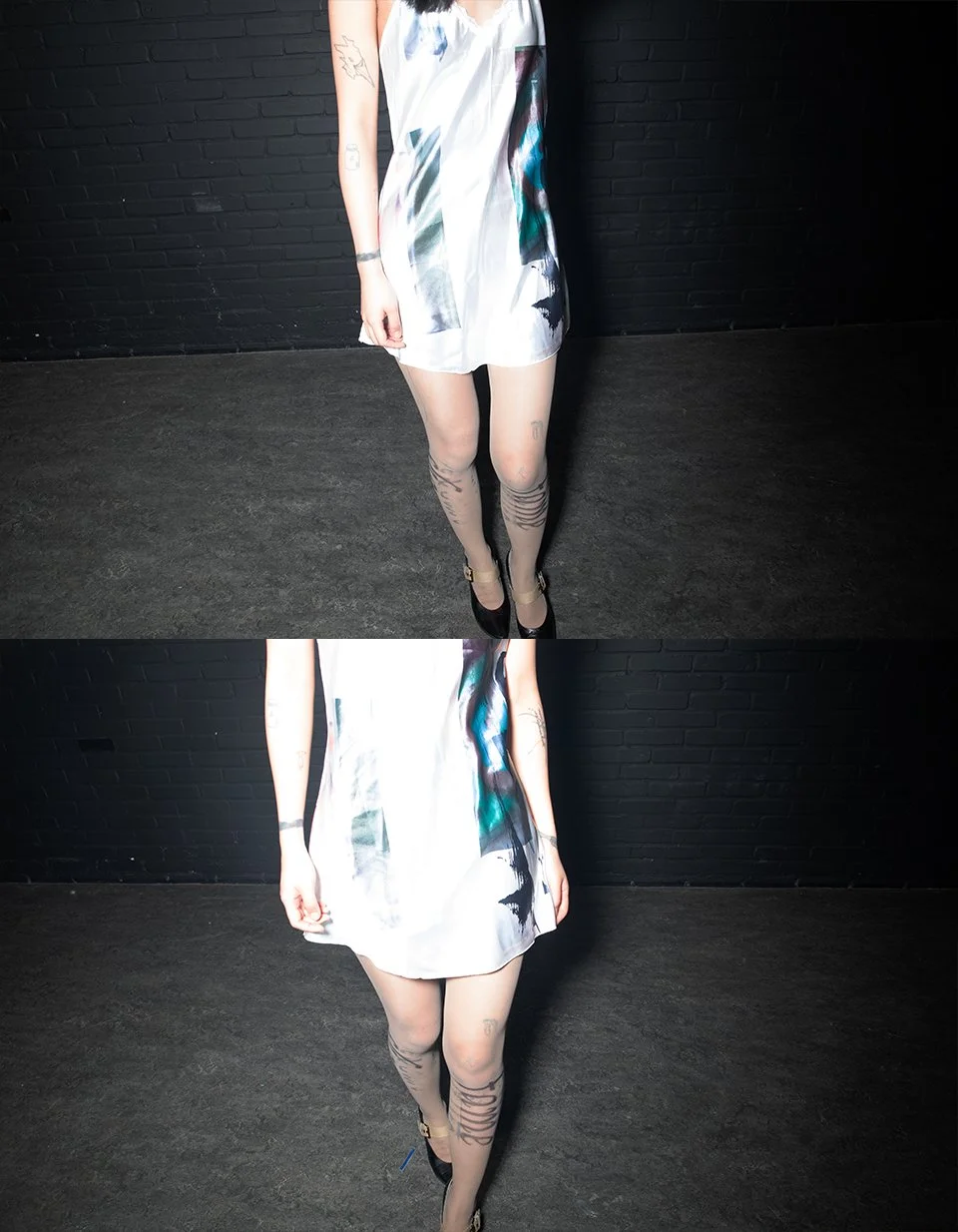 Model standing in dark room, wearing abstract-printed satin slip; tattooed legs and black heels punctuate the frame