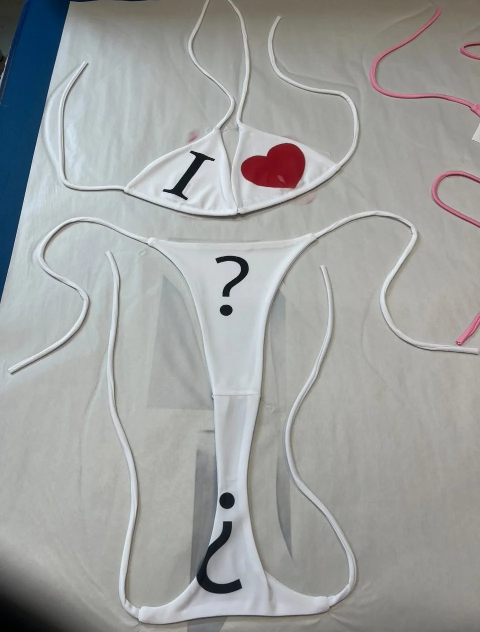 Minimalist bikini questioning love with visual symbols in bold print