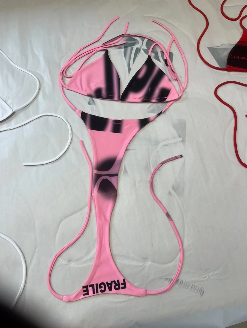 Pink micro bikini set featuring distorted anatomical print and bold “FRAGILE” lettering across the thong. One-of-a-kind statement swimwear for XS to M. Y2K, raw, unfiltered.
