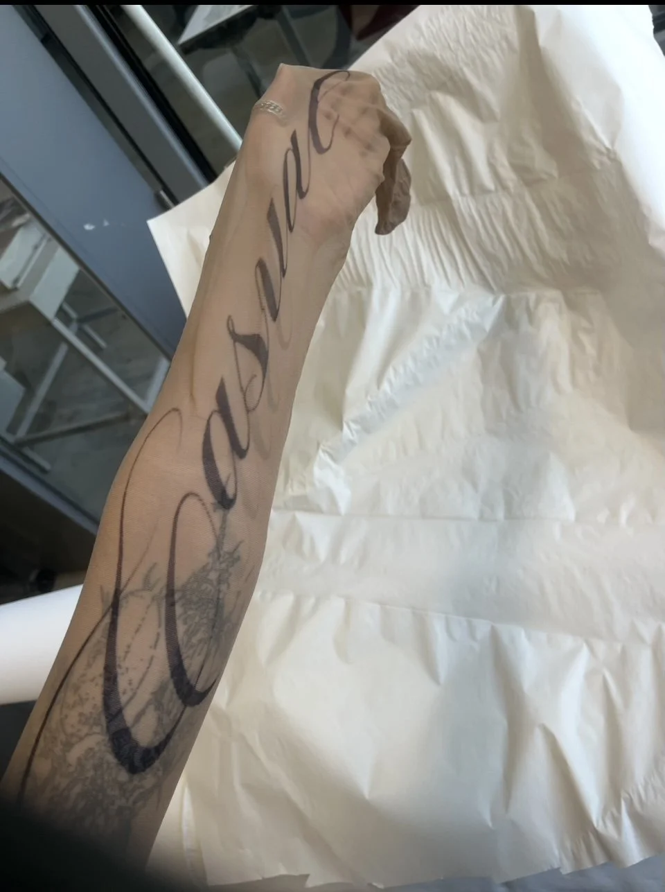 Worn example of tights on arm, showcasing “Casual” print’s tattoo-like effect.