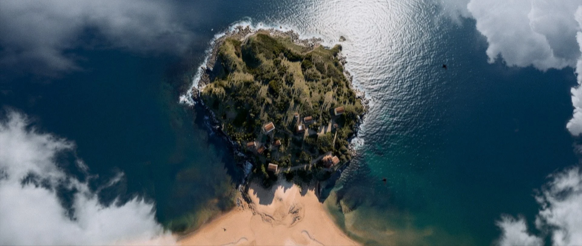 Vista de Cimavilla en Gijón en la época romana. , varias casas y un camino, rodeada por el mar y con algunas nubes en el cielo.