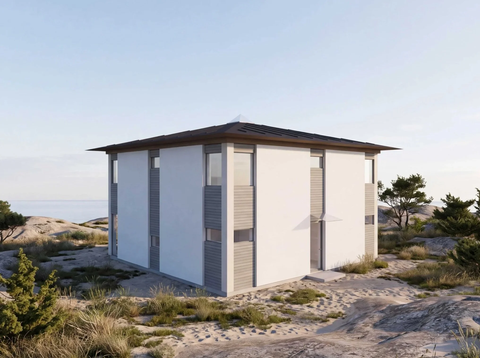 Moderna vitvilla med stora fönster på en sandstrand med gräs och små buskar, och ett klart blått himmel.