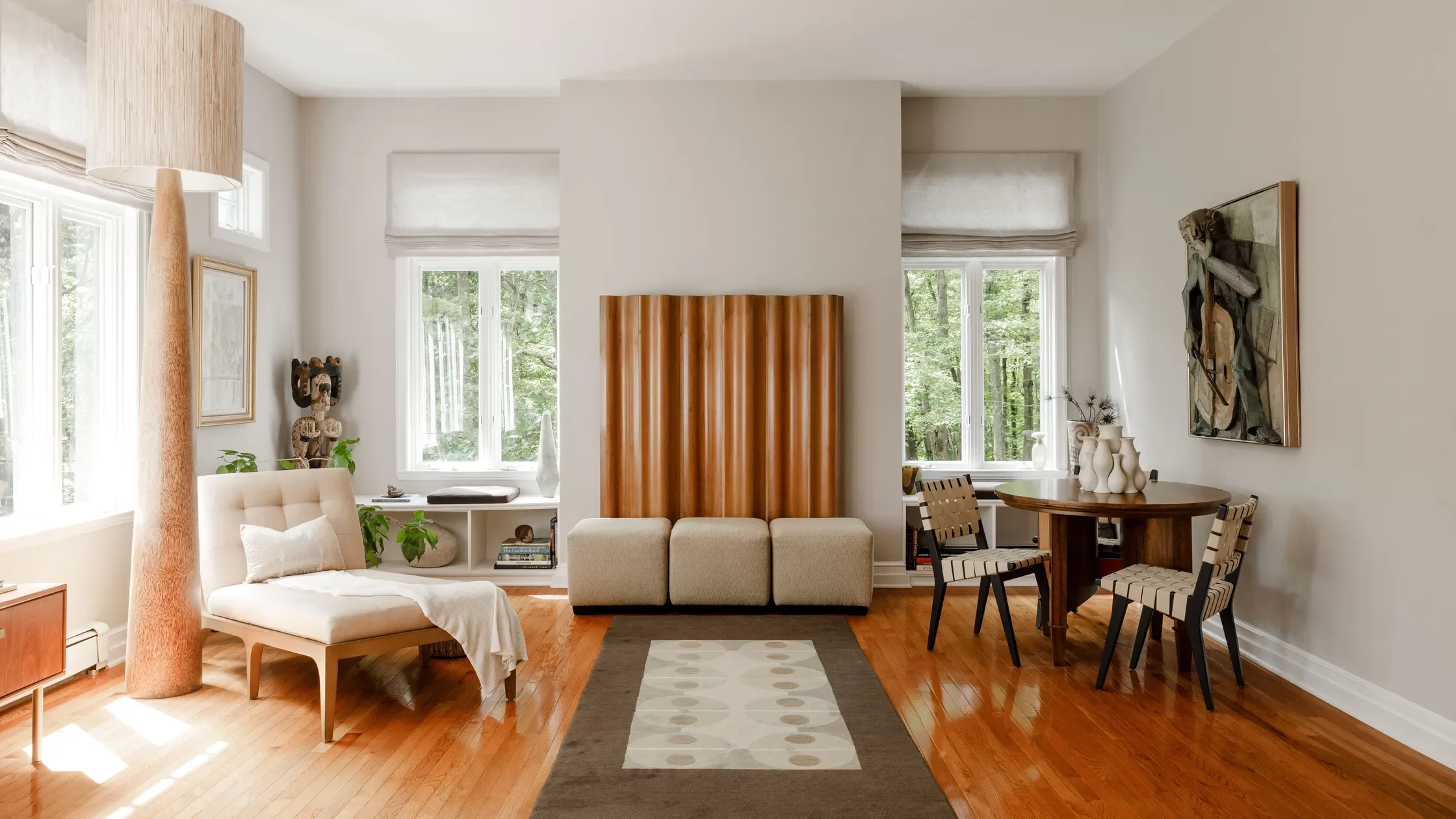 Open living and dining room featuring sculptural wood partition and layered furnishings designed by Everick Brown Design