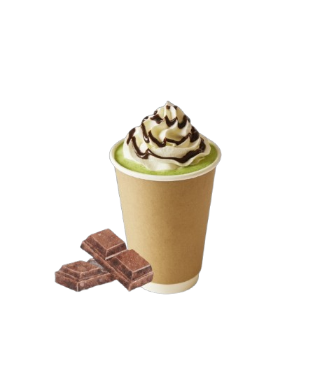 hot chocolate matcha latte topped with whipped cream and chocolate drizzle in a paper cup, with chocolate pieces beside it.