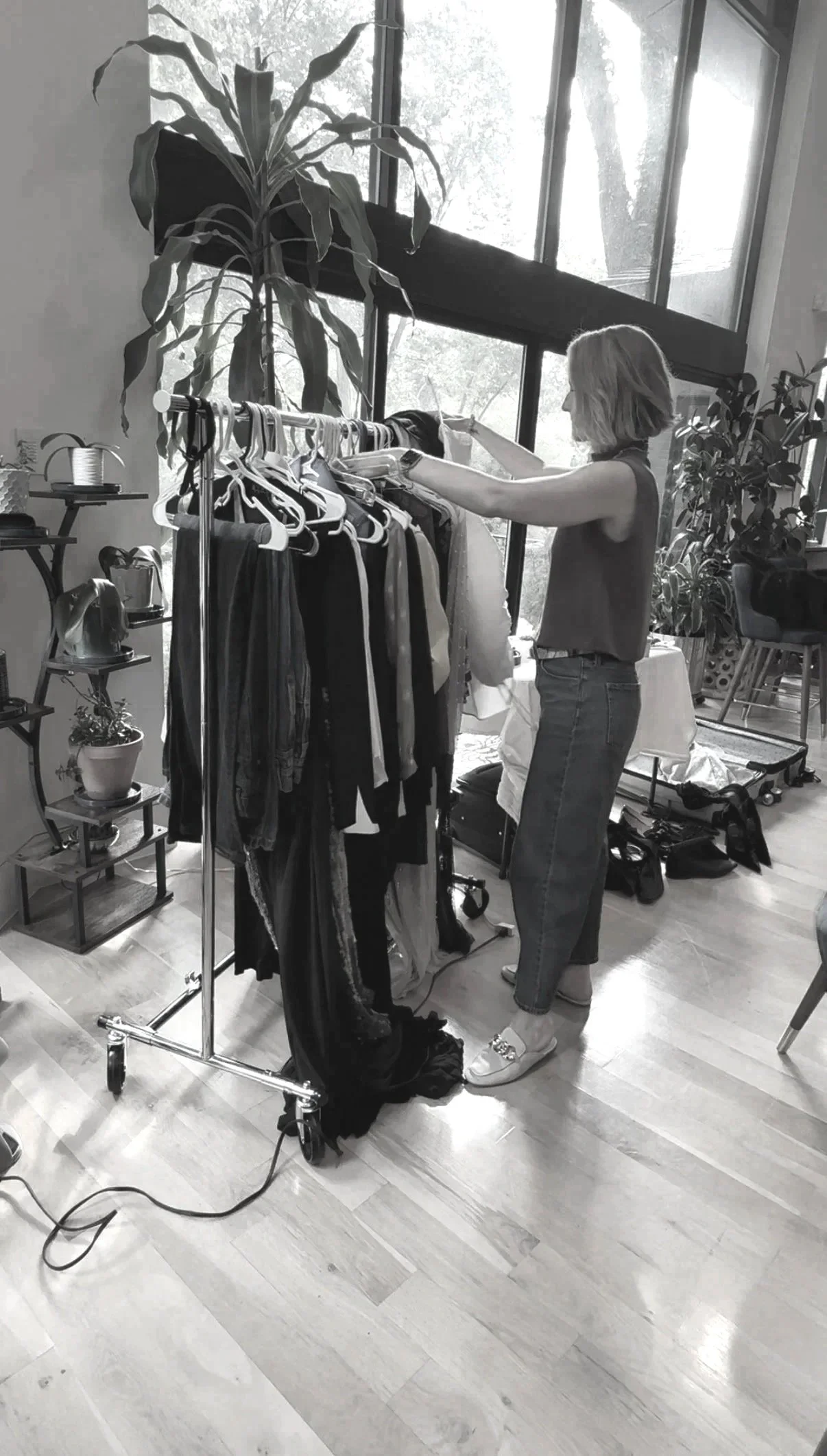 A stylist going through the garment options for the photoshoot editorial photo shoot for a model with a professional photographer on set for a clothing campaign, a wardrobe stylist working