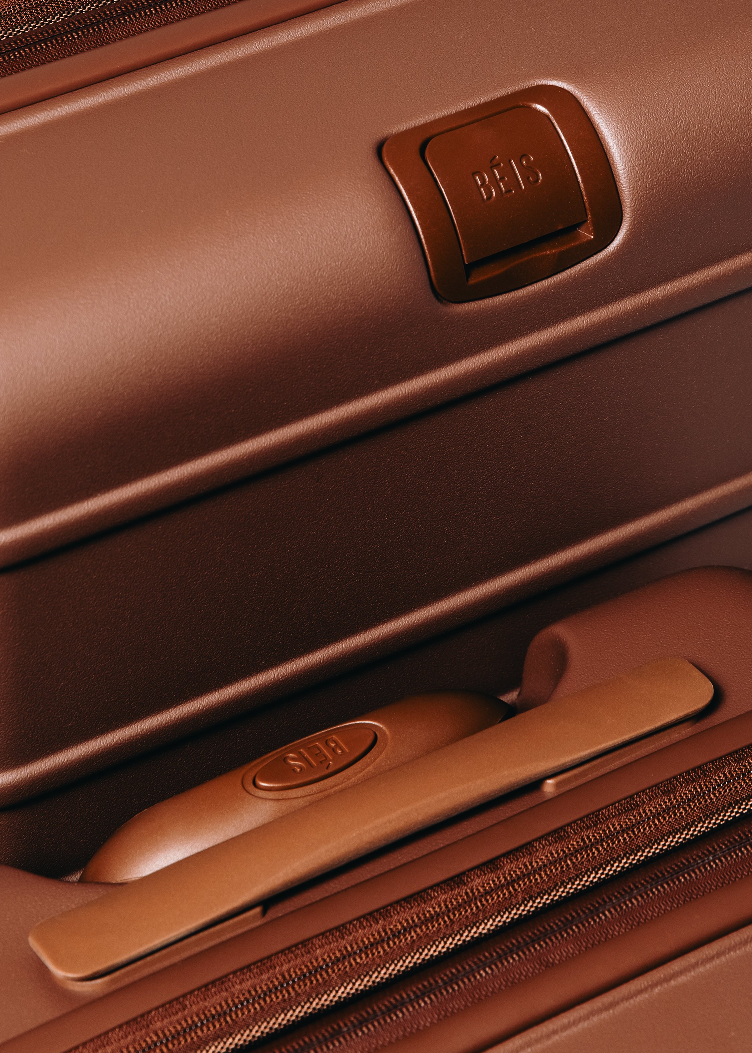 Close-up of a brown suitcase with a built-in combination lock and a handle labeled 'BÉIS'.