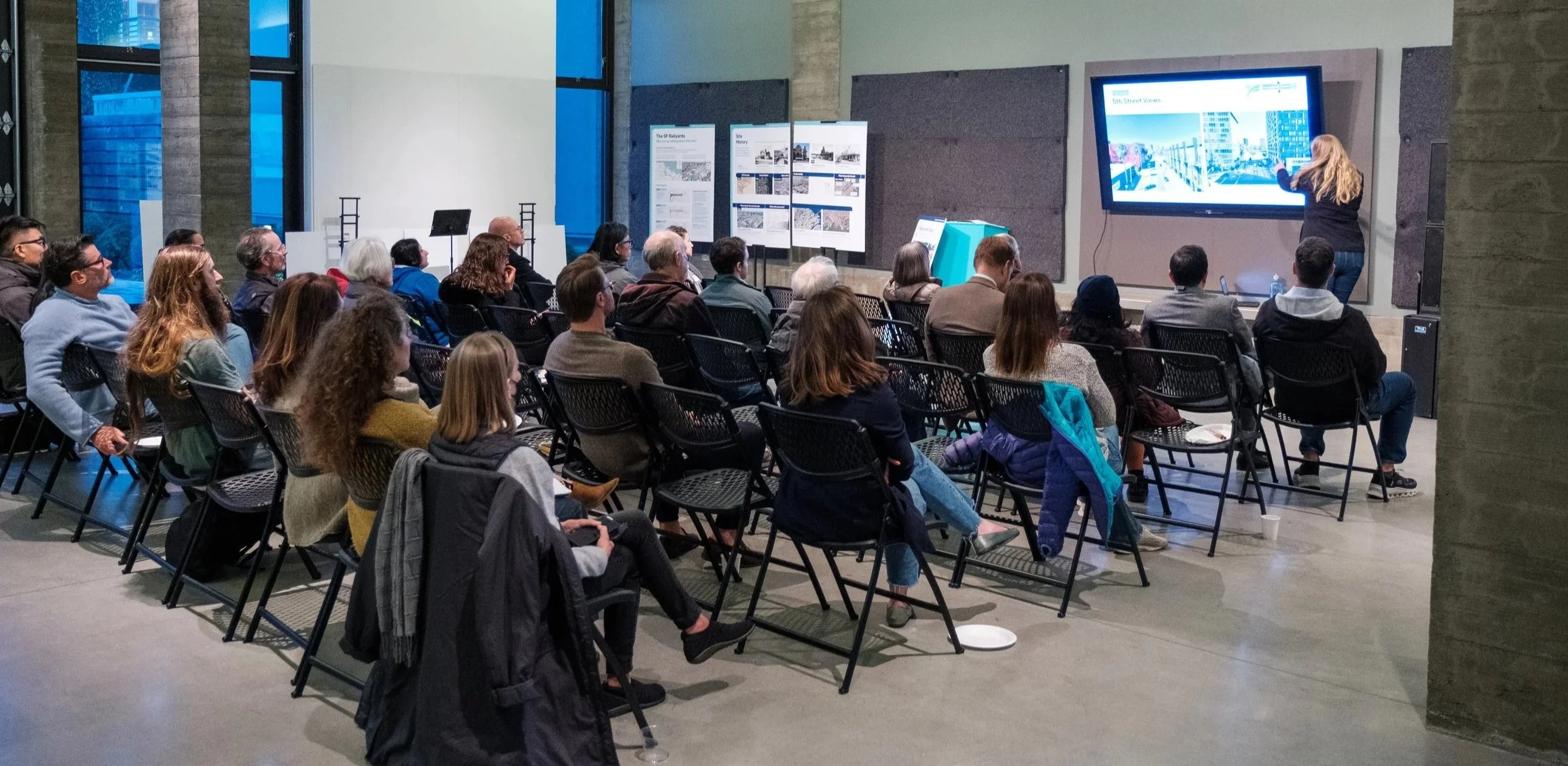 People watch a presentation at a community workshop