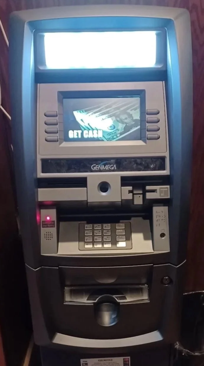 A cash withdrawal ATM with a screen displaying a message and cash illustration, featuring a keypad, card slot, and receipt dispenser.