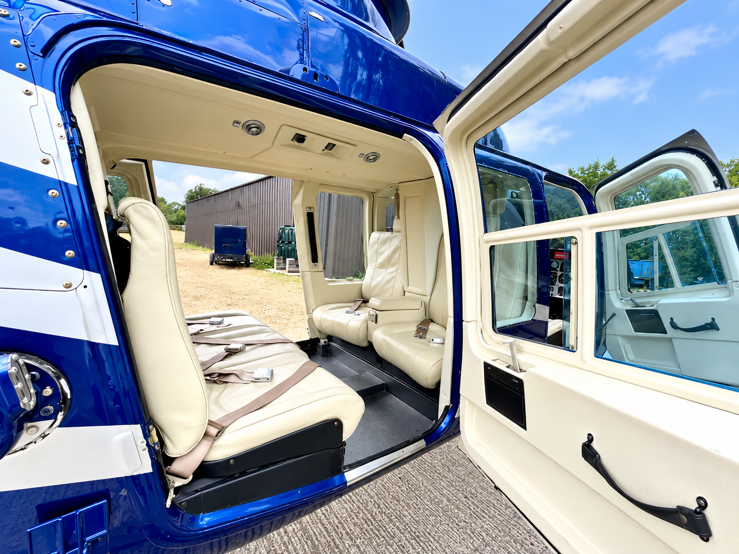 Bell 206 LongRanger cabin interior featuring cream leather passenger seating, open side door and spacious cabin layout.