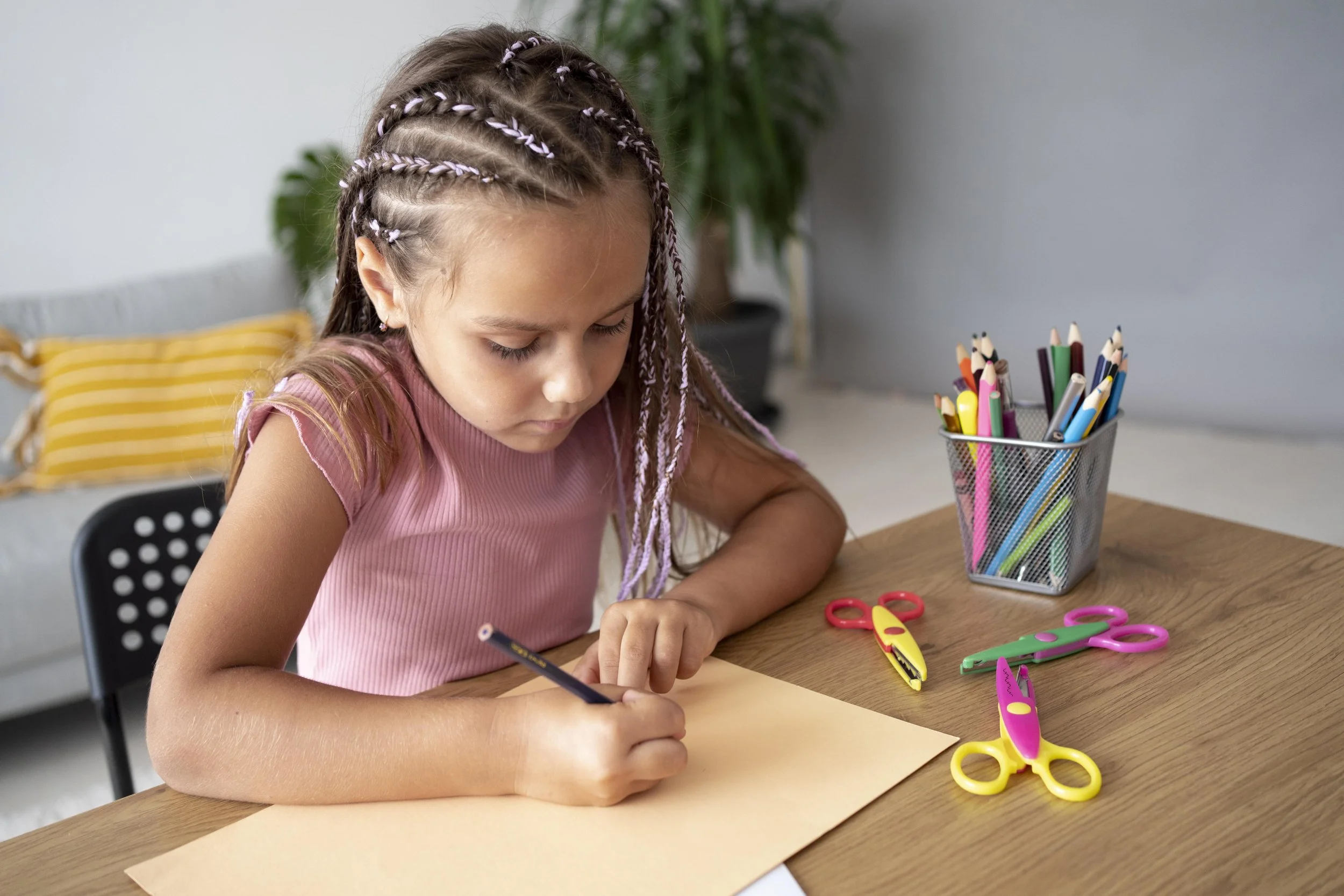 Young girl focused on a writing and fine motor activity at a desk, representing the skill-building and developmental support provided through pediatric occupational therapy at Flourish Therapy Service in Athens, GA.