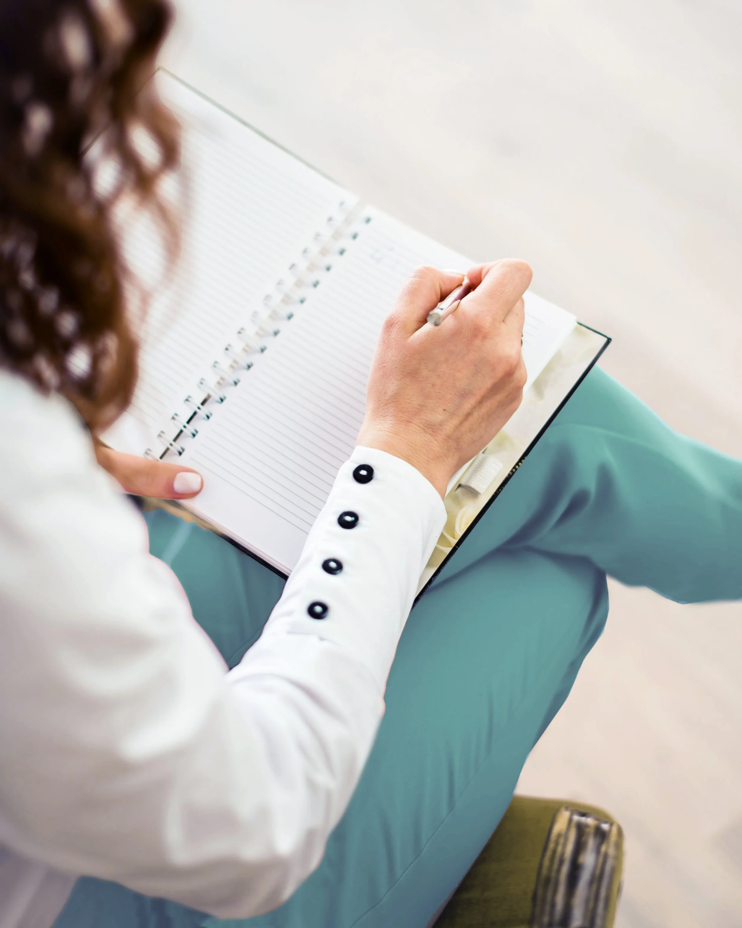 Female Doctor or Nurse Practitioner taking clinical notes on patient care.